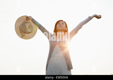 Jeune femme fermeture yeux with arms outstretched Banque D'Images