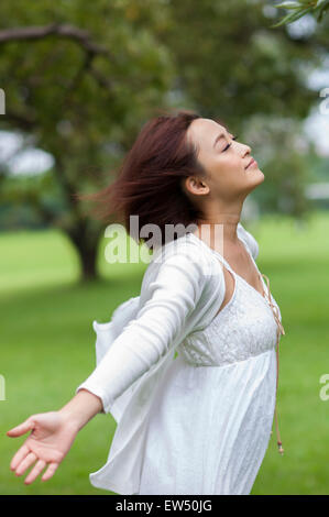 Jeune femme fermeture yeux with arms outstretched Banque D'Images