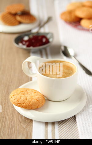 Tasse d'expresso avec des cookies à la noix de coco sur une plaque Banque D'Images