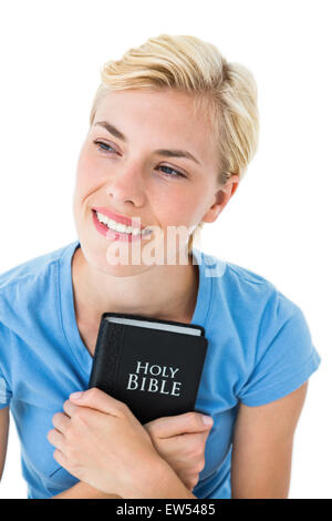 Pretty smiling blond woman holding bible Banque D'Images