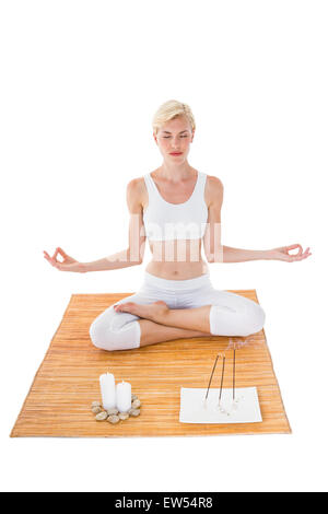 Fit woman meditating on bamboo mat Banque D'Images