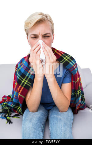 Malade blonde woman blowing her nose Banque D'Images