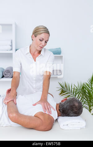 Physiothérapeute massage épaule faisant de son patient Banque D'Images