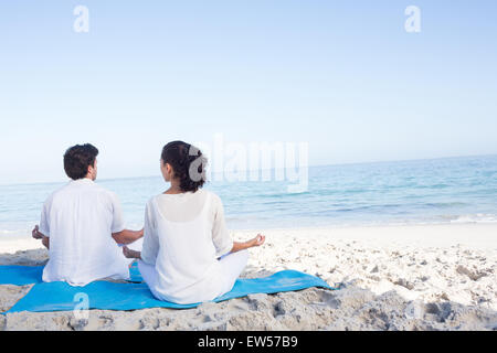 Heureux couple faisant du yoga au bord de l'eau Banque D'Images