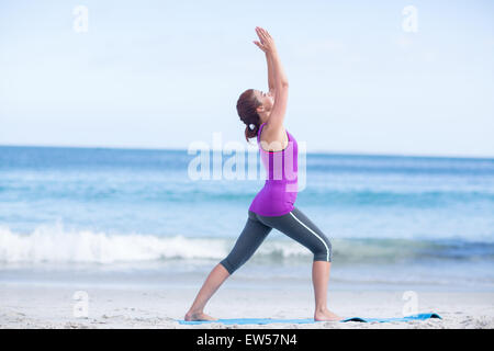 Brunette practicing yoga on exercise mat Banque D'Images