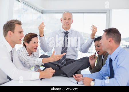 Young le 24 avec des collègues autour de colère Banque D'Images