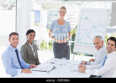 L'équipe d'affaires au cours de réunion, smiling at camera Banque D'Images