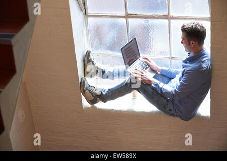 Habillé décontracté Businessman Working On Stairs In Office Banque D'Images