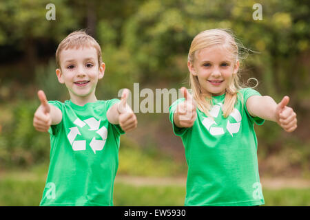 Frères et sœurs heureux en vert avec Thumbs up Banque D'Images