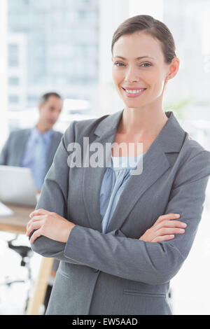 Smiling businesswoman with colleagues behind Banque D'Images