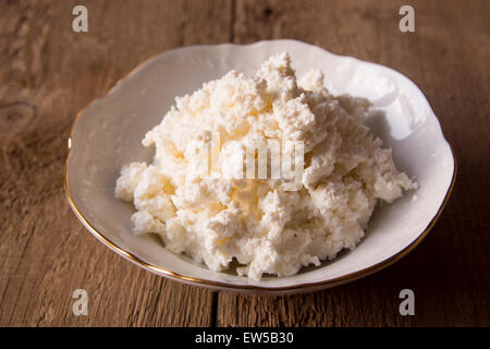 Bol de fromage cottage en blanc sur fond de bois rustique, Close up Banque D'Images