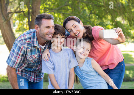 Famille heureuse dans le parc prendre selfies Banque D'Images