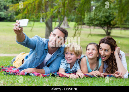 Famille heureuse dans le parc prendre selfies Banque D'Images