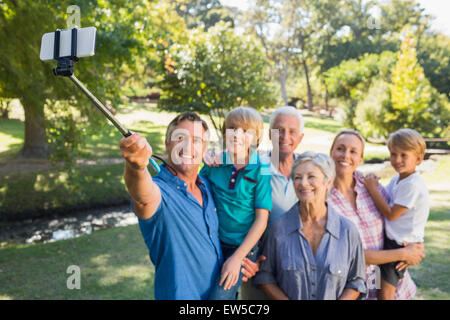 Famille heureuse à l'aide d'un bâton selfies dans le parc Banque D'Images