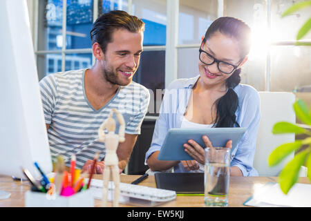 Smiling partenaires travaillant ensemble sur tablette Banque D'Images