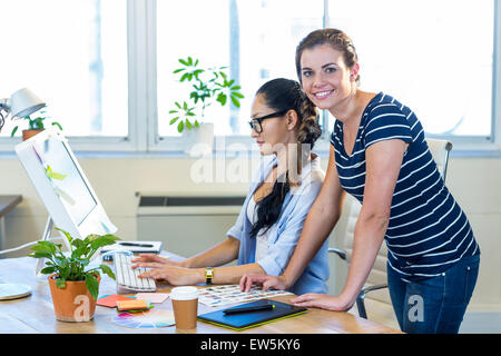 Smiling partenaires travaillant ensemble sur ordinateur Banque D'Images