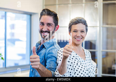 Smiling team standing Thumbs up Banque D'Images