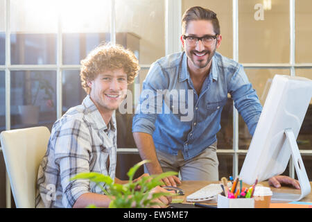 Happy business team working on computer Banque D'Images