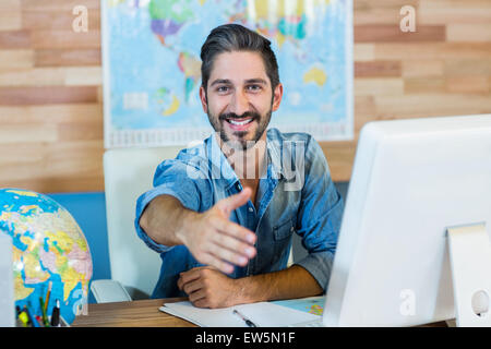 Smiling agent de voyages présentant sa main Banque D'Images