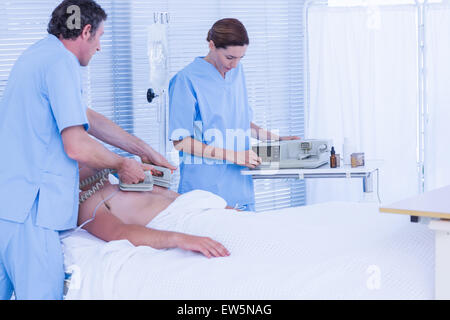 L'équipe médicale de ressusciter un homme avec un défibrillateur Banque D'Images