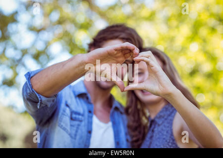 Joli couple dans le parc en forme de cœur Banque D'Images