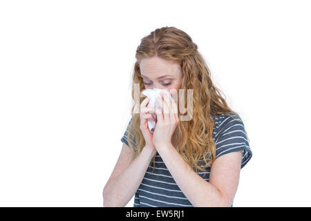 Malade blonde woman blowing her nose Banque D'Images