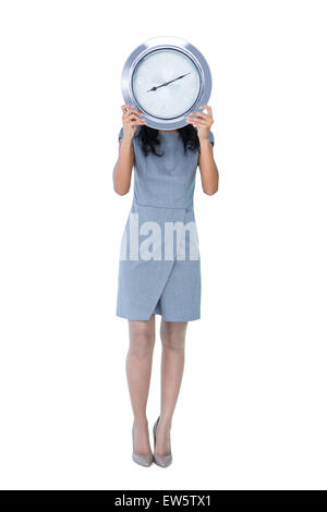 Businesswoman holding grosse horloge en face de son visage Banque D'Images