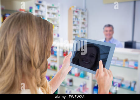 Composite image of woman using tablet pc Banque D'Images