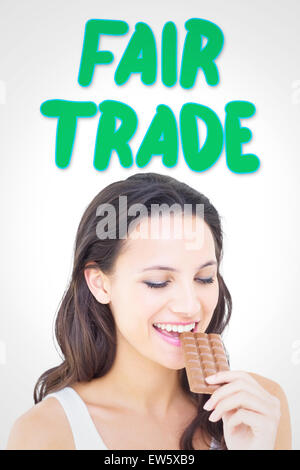 Image composite de jolie brunette eating barre de chocolat Banque D'Images