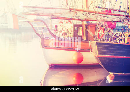 Vintage photo stylisée de vieux bateaux à voile au lever du soleil. Banque D'Images