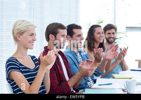 Collègues clapping hands in meeting Banque D'Images