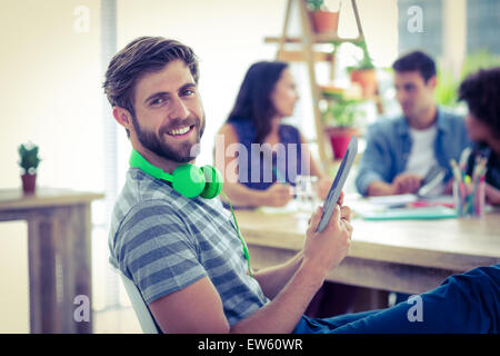 Smiling young man using digital tablet Banque D'Images