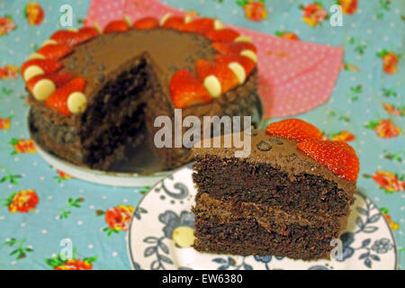 Tranche de gâteau au chocolat avec reste de gâteau en arrière-plan Banque D'Images