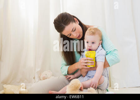 La mère et l'enfant assis sur le plancher Banque D'Images