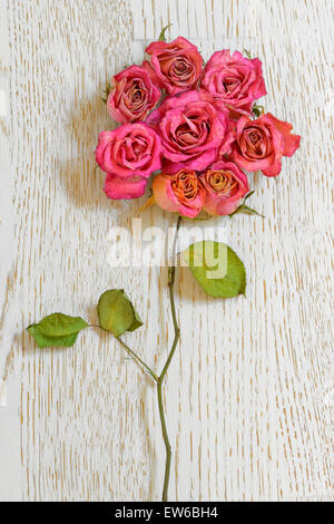 Bouquet de roses séchées sur table bois Banque D'Images