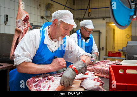 Deux bouchers couper la viande de porc à la boucherie Banque D'Images