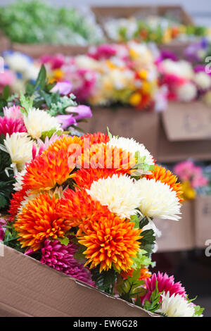 Fleurs en plastique artificielle sur l'échoppe de marché à Dorchester, Dorset, UK en Juin Banque D'Images