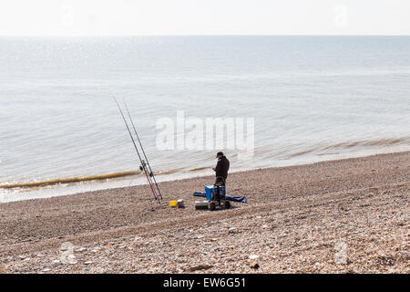 Un pêcheur à la pêche sur la plage de Kent à Dungeness Banque D'Images