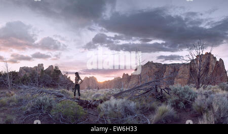 Une femme marche au sommet d'un grimpeur d'arbre tombé sur Smith Rock. Banque D'Images