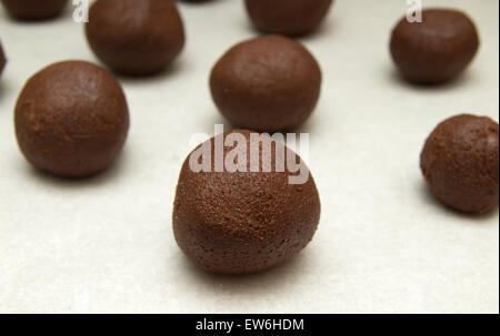 La fabrication du chocolat cookies - petites boules de mélange de chocolat sur le papier sulfurisé Banque D'Images