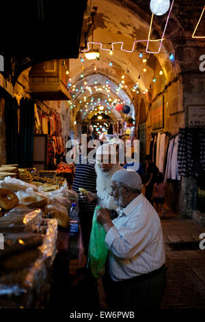 Israël, Jérusalem. 18 Juin, 2015. Palestiniens acheter du pain après le jeûne dans une ruelle dans le quartier musulman avec lumières de fête pendant le mois du Ramadan dans la vieille ville de Jérusalem le 18 juin 2015. Les musulmans du monde entier comme le Ramadan un mois de jeûne et il est considéré comme l'un des cinq piliers de l'Islam. Credit : Eddie Gerald/Alamy Live News Banque D'Images