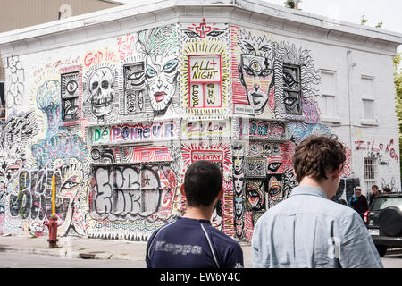 Deux personnes se réveillant devant Une photo d'un bâtiment Corner avec des graffitis colorés couvrant tous les côtés des murs à Montréal. Effet grunge, toile de fond, Banque D'Images