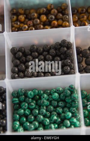 Perles perles en pierres séparées dans des récipients en plastique pour l'artisanat Bijoux artistique. Banque D'Images