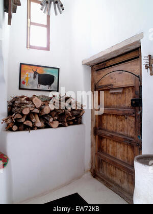 Les journaux stockés sur la tablette en pierre rustique à côté de la porte en bois en blanc moderne hall marocain Banque D'Images