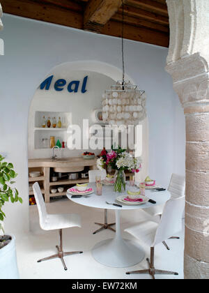 Abat-jour au-dessus de la coquille et des chaises en cuir blanc Tulip set de table pour le déjeuner dans la salle à manger marocaine Banque D'Images