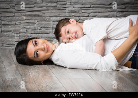 La mère et le fils de câlins sur le plancher Banque D'Images