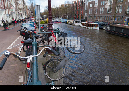 Des vélos garés le long d'un canal dans le centre-ville d'amsterdam Banque D'Images