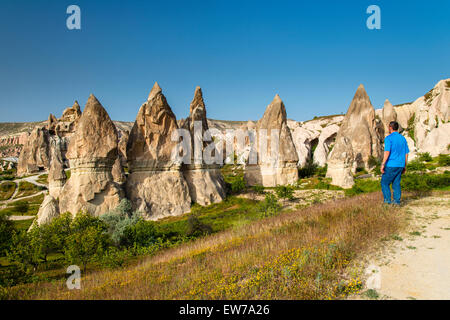 Homme de race blanche'regardant les cheminées de fées près de Göreme, Cappadoce, Turquie Banque D'Images