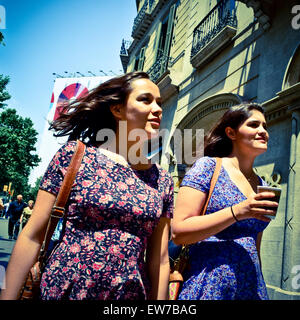 Deux jeunes femmes portant des robes florales walking down street. Barcelone, Catalogne, Espagne. Banque D'Images