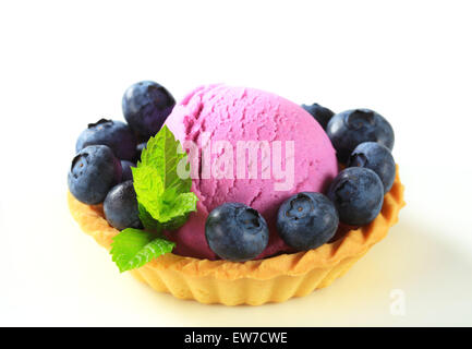 Écope de la crème glacée aux fruits avec des bleuets frais dans un fond de tarte Banque D'Images